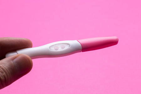 Pregnancy test with a positive result in the form of the heart. Pink isolated background.の写真素材