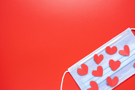 Medical mask with a heart on a red background. Valentines Day.の写真素材