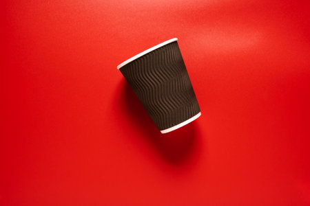 Brown paper cup for coffee or tea on a red background.の写真素材