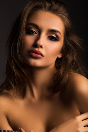 Portrait of a beautiful brunette on a gray isolated background. Luxurious girl with beautiful lips.の写真素材