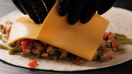 Cooking quesadilla close-up on a black background. Step by step food preparation.の写真素材