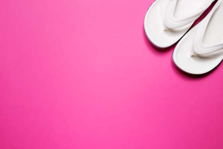 Flip flops on a pink isolated background. White female flip flops.の写真素材