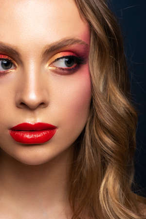 Close-up portrait of a beautiful model with a bright make-up and red lips.の写真素材