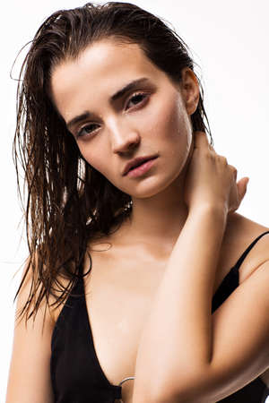 Portrait of a beautiful brunette with wet hair on a white backgroundの写真素材
