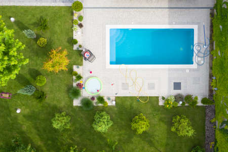Aerial shot of green lawn and garden with a swimming pool in the courtyard.の写真素材