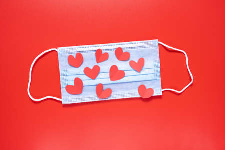 Medical mask with a heart on a red background. Valentines Day.の写真素材