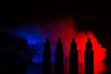 Fluid for electronic cigarettes with a background of a colored cloud of smokeの写真素材