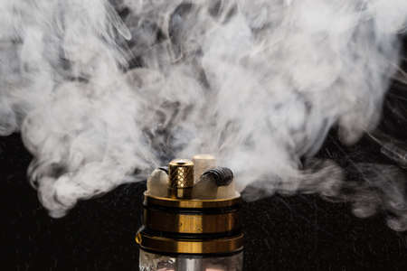 Vape close-up with smoke on a black backgroundの写真素材