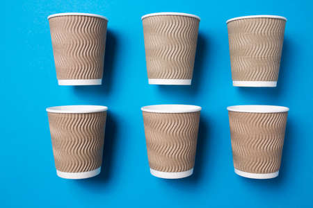 Paper cup for hot coffee or tea on a blue isolated background.の写真素材
