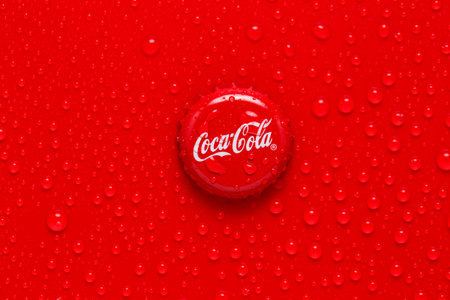 Kiev, UKRAINE - January 28, 2019: classic cap close-up of Coca-cola. Cap of cola on a red background...
