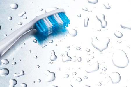 Blue toothbrush close-up on a light background with drops of water