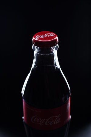 Kiev, UKRAINE - January 12, 2017: glass bottle of coca cola on black background close-up