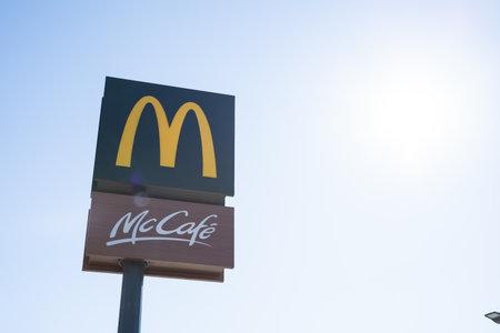Tarragona, Spain - February 02 2023: Signboard McCafe andMcDonalds against the blue sky.のeditorial素材