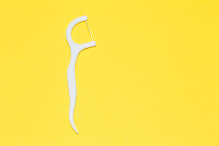 Plastic toothpick on a yellow isolated background. Hygiene and dental care.の写真素材