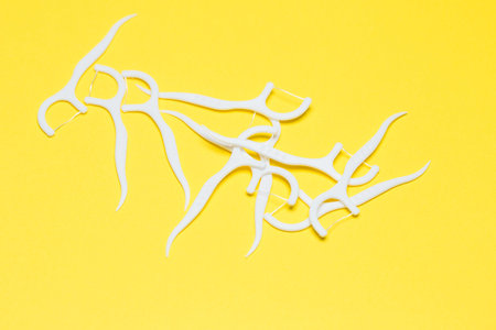 Plastic toothpick on a yellow isolated background. Hygiene and dental care.