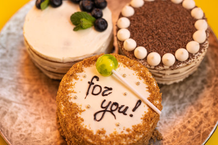 Three bento cakes with different designs on a yellow background.の写真素材