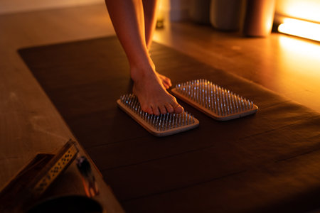 Womens feet stepping on sharp nails for meditation, sadhu wooden board. Yoga practiceの写真素材