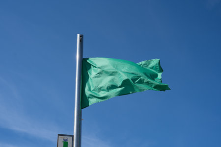 Beach green flag weather wind advice Spain blue seaの写真素材