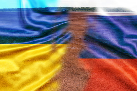 Flags of Ukraine and Russia on the background of the dried earth. Military conflict in Europe leads to drought and scorched earth.の写真素材