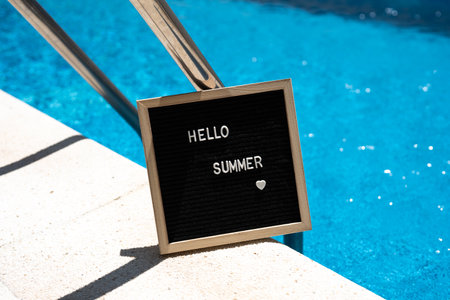Hello summer text on chalkboard on pool background on summer sunny day.の写真素材