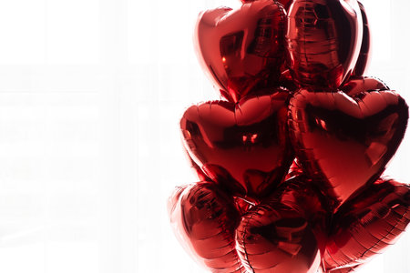 A floating bouquet of red, heart-shaped balloons on a white background.の写真素材