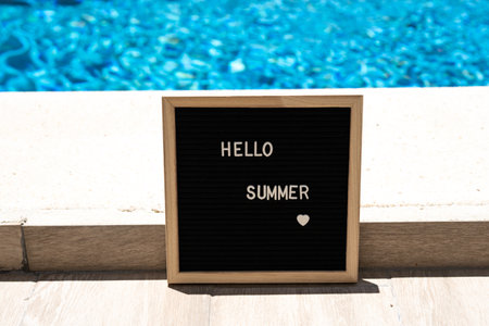 Hello summer text on chalkboard on pool background on summer sunny dayの写真素材