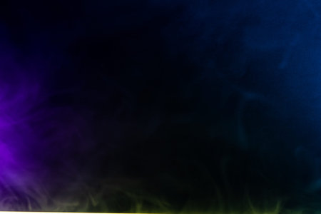 Blurred photo texture of colored smoke on a black background.