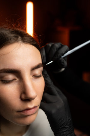 An engaging eyebrow styling session showcasing precision and artistry through innovative techniquesの写真素材