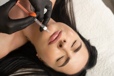 Syringe near womans chin, beauty injections with fillers for chin shape correction.の写真素材