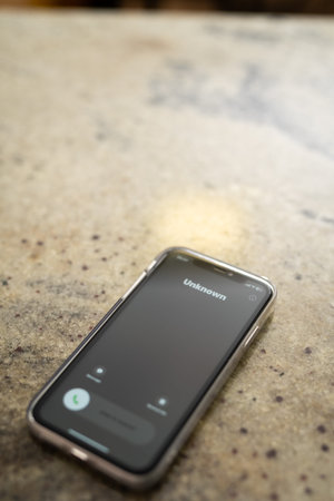 Fraud or fraudulent schemes. Close-up of a phone with an unexpected incoming call from an unknown...