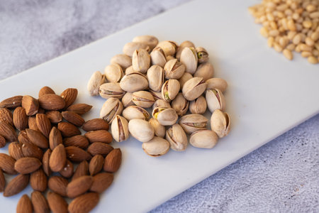 Almonds and pistachios closeup. Artistic presentation of almonds and pistachios emphasizing healthy...