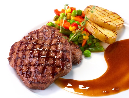 Rib-eye steak with vegetables on whiteの写真素材