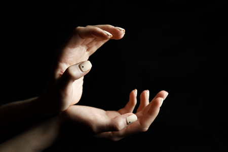 Female hands on black background shows gesturesの写真素材
