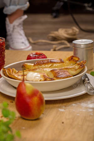 Pancakes in butter and sour cream on wooden table, strawberry juice, baked Apple.の写真素材