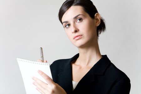 Young secretary or businesswoman with pen and spiral note-bookの写真素材