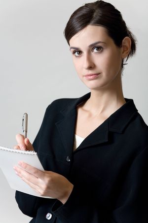 Young secretary or businesswoman with pen and spiral note-bookの写真素材