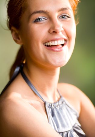 Portrait of happy lovely sweet smiling redhaired girl, outdoorsの写真素材