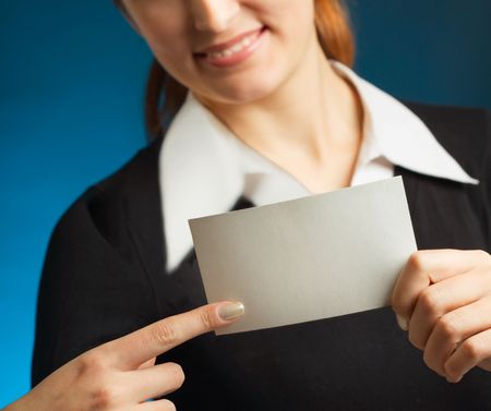 Young attractive secretary or businesswoman with sign or blank facture business-card, smiling. Focus on card.の写真素材