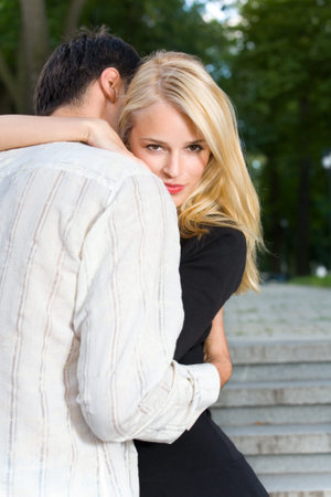 Young happy embracing couple walking together outdoorsの写真素材