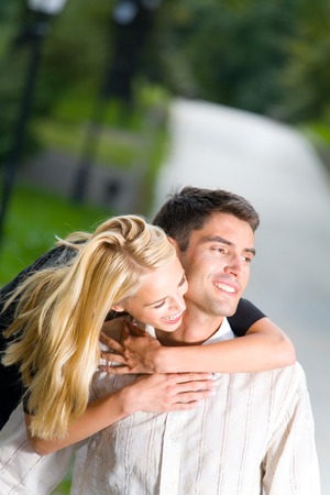 Young happy smiling embracing couple walking together outdoors. You can use top part as copyspace.の写真素材
