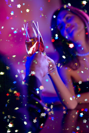 Young happy couple with champagne glasses at celebration. Focus on glasses.