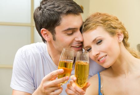 Young couple celebrating with champagne at homeの写真素材