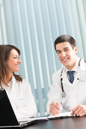 Two happy medical people working together at officeの写真素材