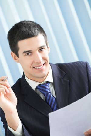Happy businessman with document at officeの写真素材