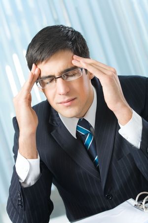 Tired or ill businessman at officeの写真素材