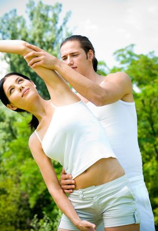 Young happy couple doing fitness exercises together outdoorsの写真素材