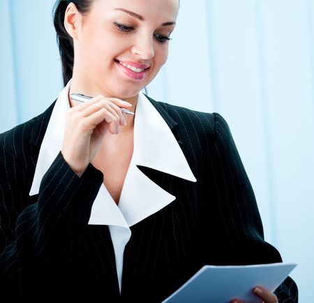 Happy smiling businesswoman with pen at officeの写真素材