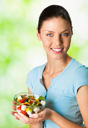 Young happy smiling woman with salad, outdoorの写真素材