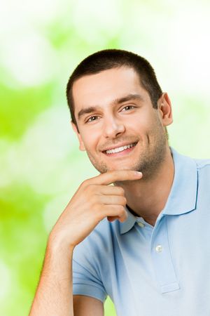 Portrait of young attractive smiling man, outdoorsの写真素材