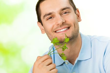 Young attractive happy smiling man with potherbsの写真素材